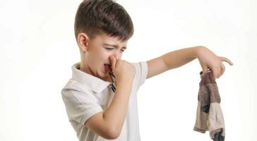 Studio shot of young boy holding stinky sock